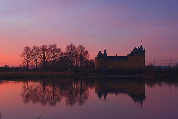 The swedish medieval Kalmar Castle at evening with steam lines in the sky.