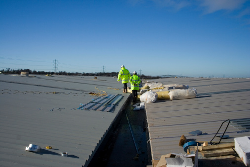Architect roof inspection at new factory construction site