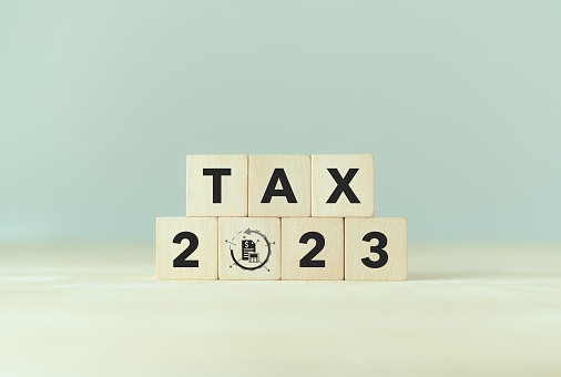 TAX in 2023 concept, on wooden block. State taxes,tax payment, governant ,calculating finance, tax accounting, statistics and data analytic reserach, calculation tax return, strategy plan, report.