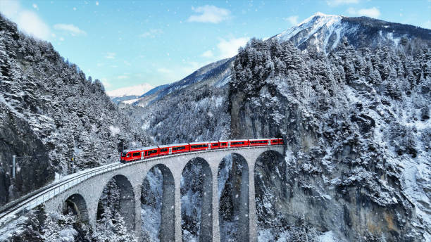 istock Snow falling and Train passing through famous mountain in Filisur, Switzerland. Train express in Swiss Alps snow winter scenery. 1826593744