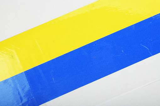 Abstract white background made of paper, blue and yellow tape.