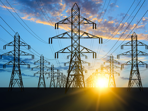 Electricity power pylons with sunset on background