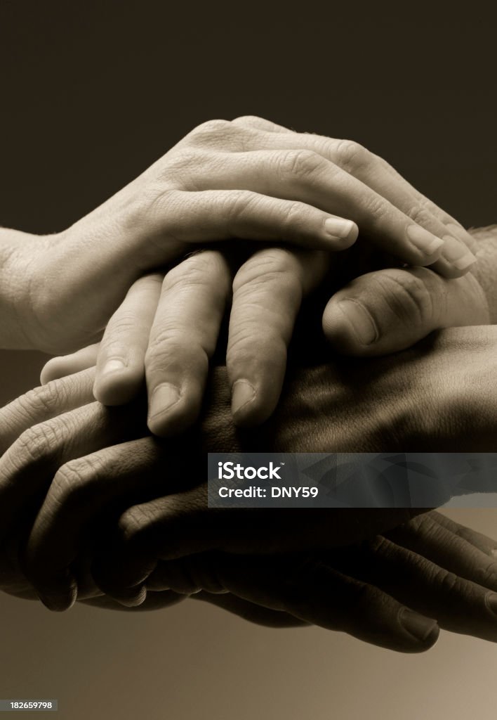 Unity Four hands clasped together in unity Black And White Stock Photo