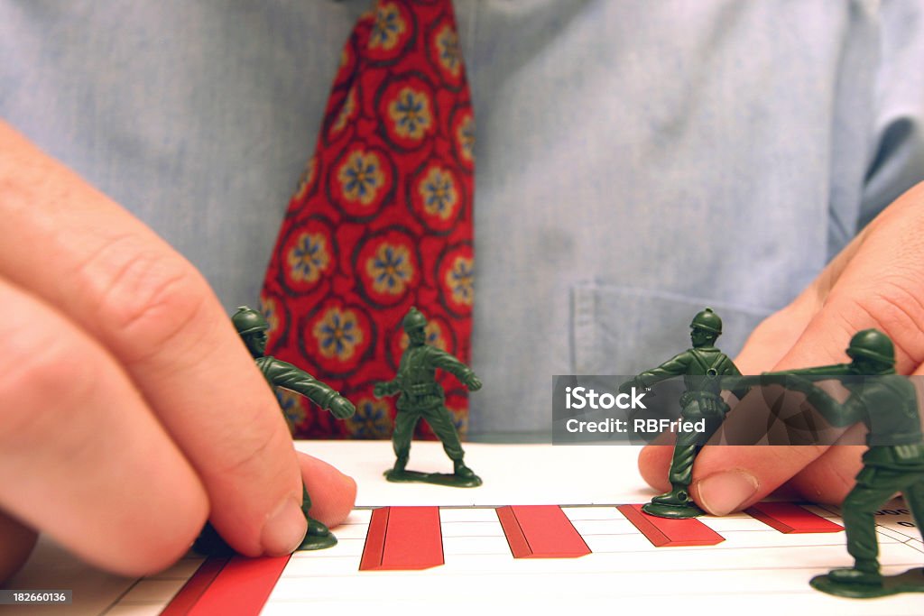 Business is War a businessman playing with army men Fighting Stock Photo