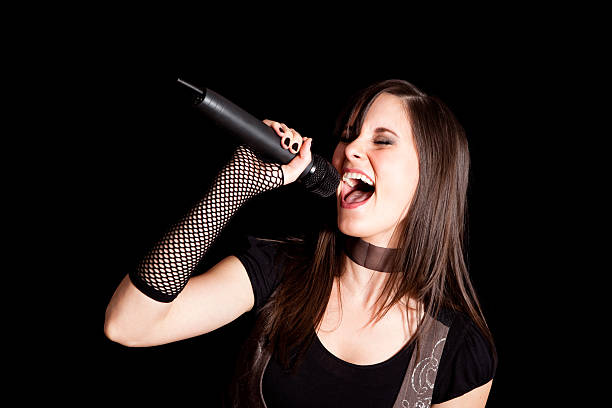 istock Happy Rocker Girl Singing into Microphone on Black Background 182660861