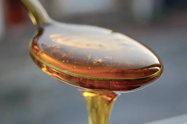 Photo of A spoonful of golden syrup overflowing from it