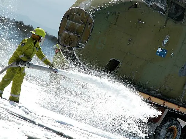 Fire fighter controls foam from hose at tarmac emergency exercisesee also: