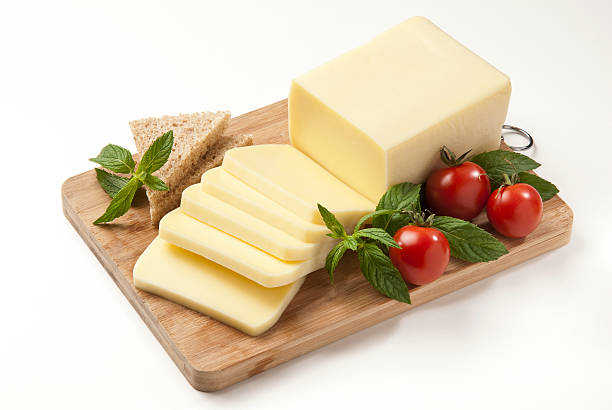 Sliced cheese, tomatoes and herbs in a cutting board "cheese, tomatoes and mint with cutting board" cheddar cheese photos stock pictures, royalty-free photos & images