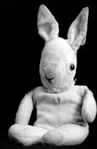 picture of an old and well loved bunny rabbit soft toy. Black and white.