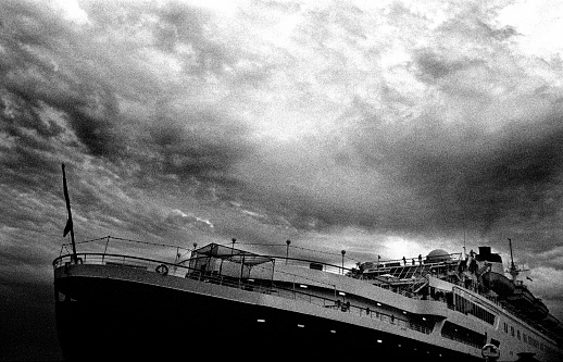 Heavy image with a large cruse ship seems to be sinking. Strong moody sky with a bit of grain making this image that much stronger.