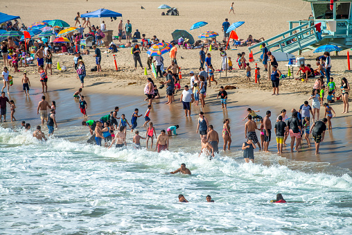 People enjoy the beach in Capitola, Santa Cruz, California, USA on a sunny day.