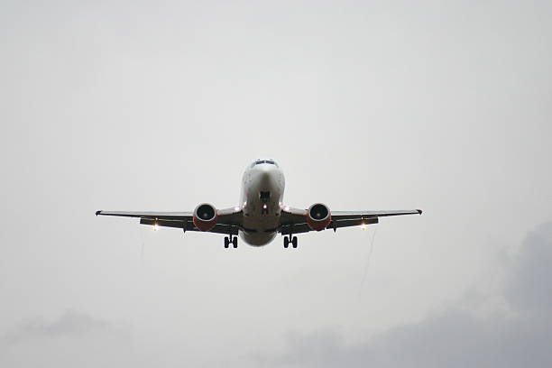 Landing "A passenger jet landing out of grey skies at Stansted Airport (STN), Essex." gatwick airport photos stock pictures, royalty-free photos & images