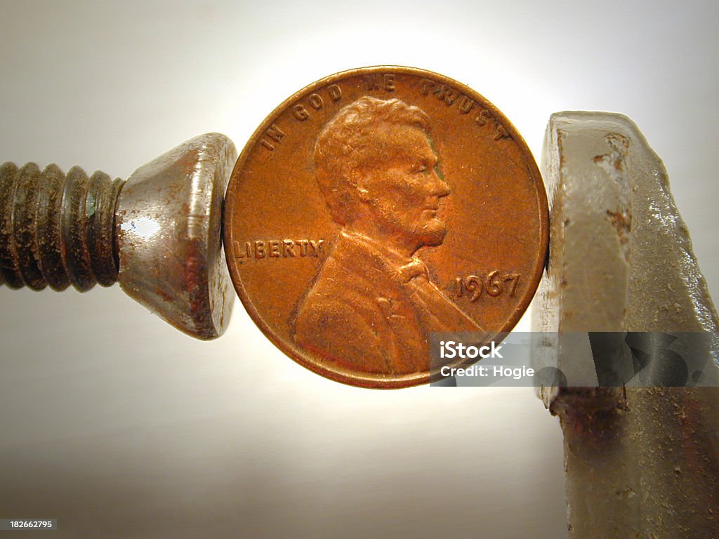 Pinching Pennies An American penny in a C-clamp.Check out Miserly Stock Photo