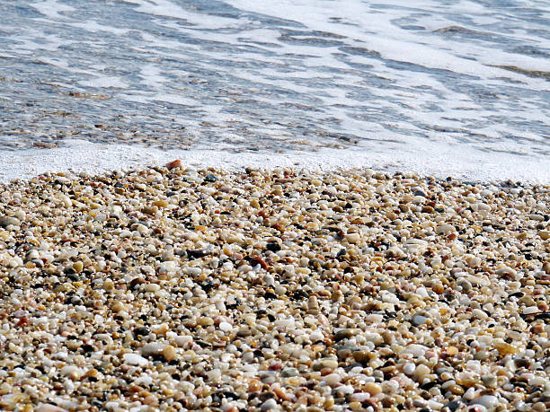 istock Pebbles on the beach with foamy water 182663030