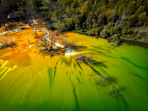 Abstract patterns formed of toxic waste from copper and gold mining operations. Drone photo taken on 14th of October 2023 on the Geamana lake, near Rosia Montana, Romania.