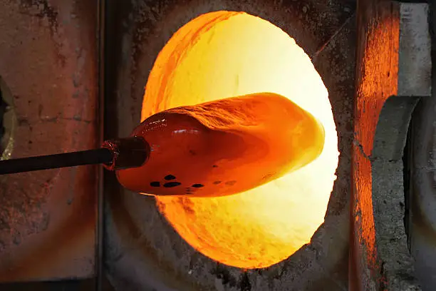 Burning furnace with a glassblowers object. Focus at the end of the pipe.