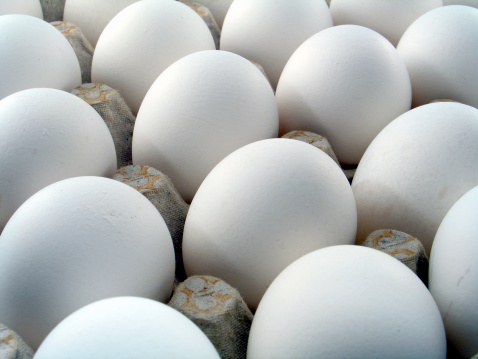 Close up of a couple dozen hens eggs.