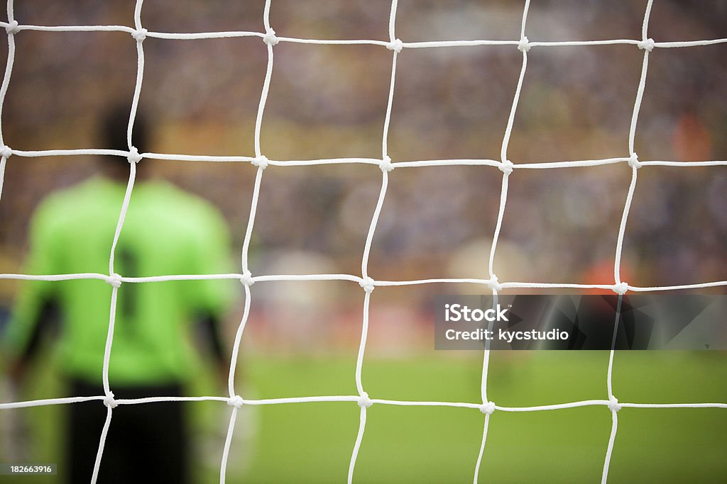 Soccer Goal Box With Goalie "Closeup view of a soccer goal with a player, field and stadium visible through the netting. Horizontal shot, shallow dof.see also:" Net - Sports Equipment Stock Photo