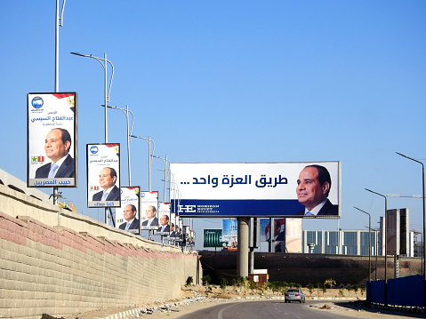 Cairo, Egypt, November 30 2023: Egyptian presidential election campaign banners, Egypt's president election 2024 advertisement near Cairo monorail site with columns and tracks under construction, selective focus