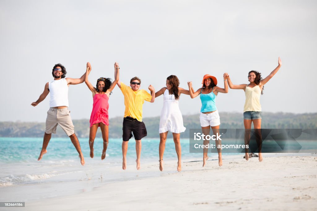 Группа молодых людей прыгать в тропический Пляж - Стоковые фото 18-19 лет роялти-фри