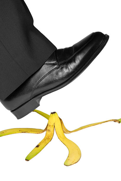 Look Out! foot of man in business suit about to slip on banana peel slapstick comedy stock pictures, royalty-free photos & images