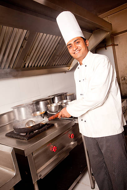 istock Cheerful Indian Chef working cooking in a Restaurant Kitchen Vertical 182666127