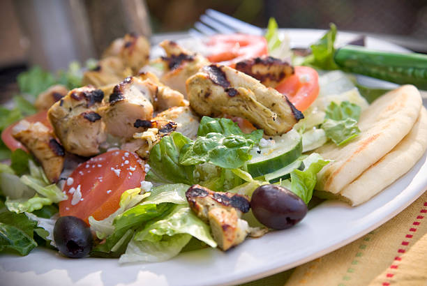 saudável salada de legumes grega com frango grelhado, queijo feta & pão árabe - greek cuisine chicken grilled grilled chicken - fotografias e filmes do acervo