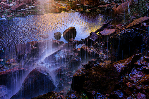 Waterfall View from Behind with Cascading Flowing Water Over Rocks - Scenic desert landscape in oasis canyon area.