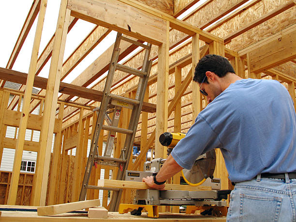 istock Construction Site: Man with Safety Glasses Uses Miter Saw 182666995