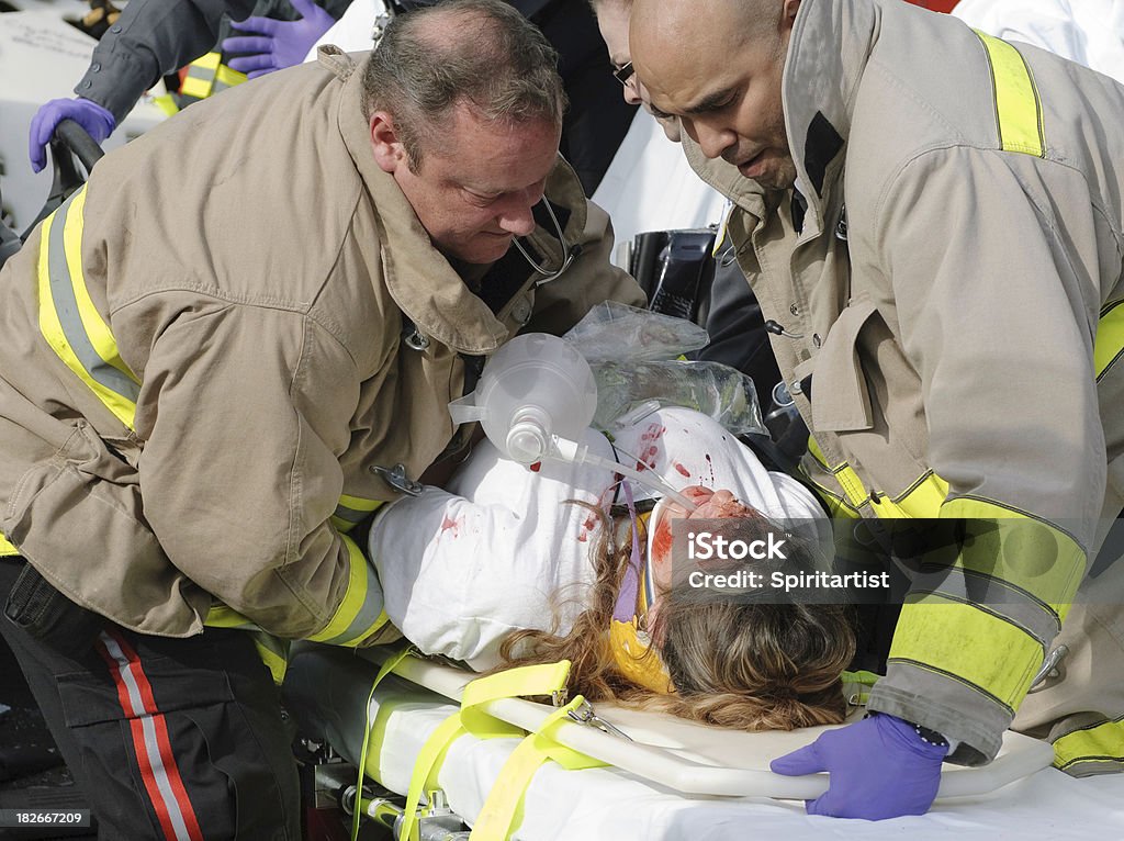 EMTs inferior paciente para uma maca - Foto de stock de Acidente royalty-free