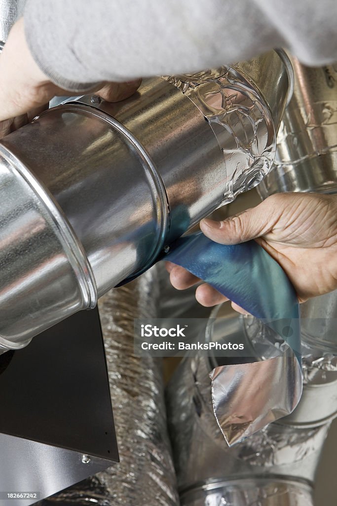 Worker Wrapping an HVAC Air Duct with Foil Tape  Air Conditioner Stock Photo