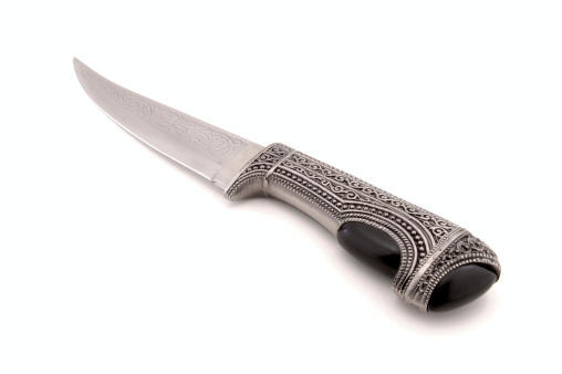 An ornate silver Medieval dagger.  Ebony jewels and detailed engraving on handle and blade.