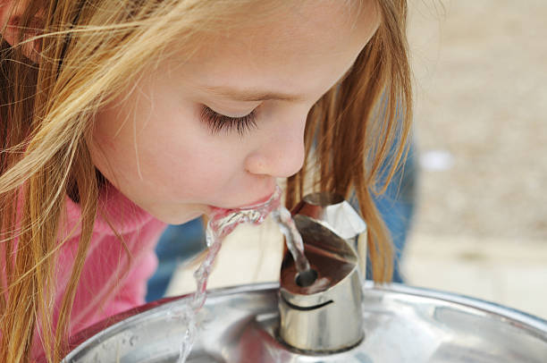 Drinking fountain Child getting a quick drink. drinking fountain stock pictures, royalty-free photos & images