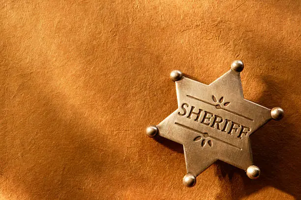 Sheriff's badge on warm textured surface with room for body copyFor more legal images click here: