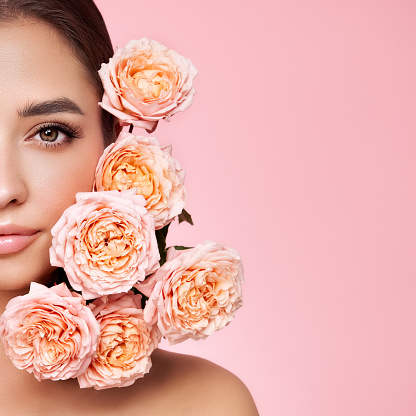 Portrait beautiful young woman with clean fresh skin. Model with healthy skin, close up portrait. Cosmetology, beauty and spa. Girl with a rose flower