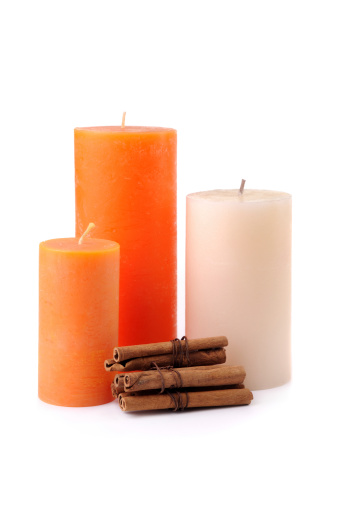 Candles and cinnamon sticks isolated on white.