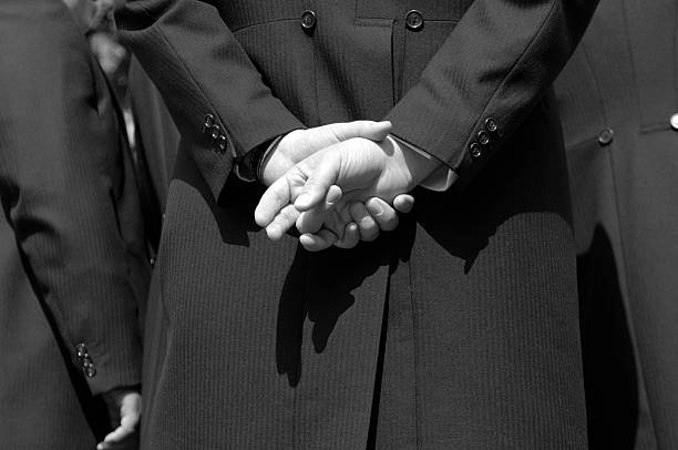 Close up of a grooms hands folded together.