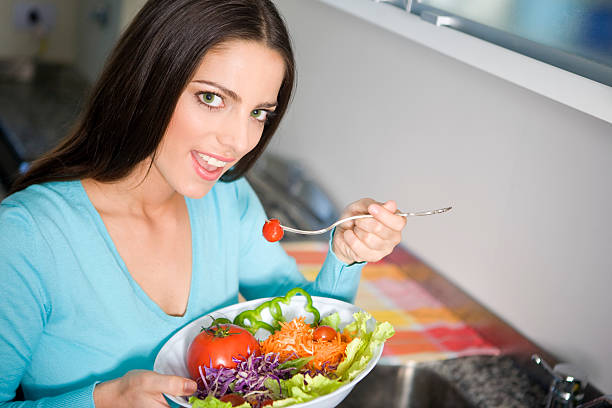 istock Young Woman Eating Salad 182670368