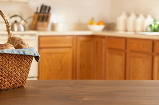 Kitchen counters and a basket of rolls on the table. Empty space for that perfect product.