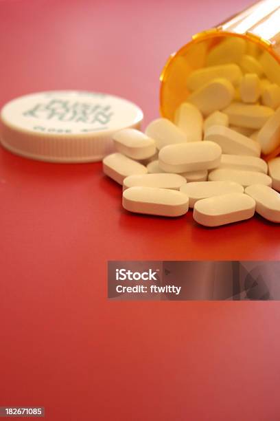 Flacone Di Pillole Su Rosso Verticale - Fotografie stock e altre immagini di Abbondanza - Abbondanza, Accudire, Bottiglia