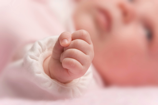 Hand of a baby girl just weeks old.