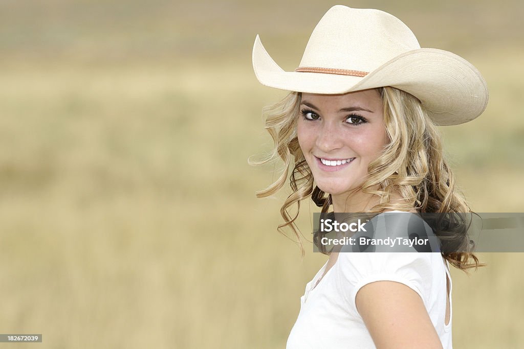 Happy Cowgirl Woman with cowboy hat smiling. Shallow DOF Adult Stock Photo