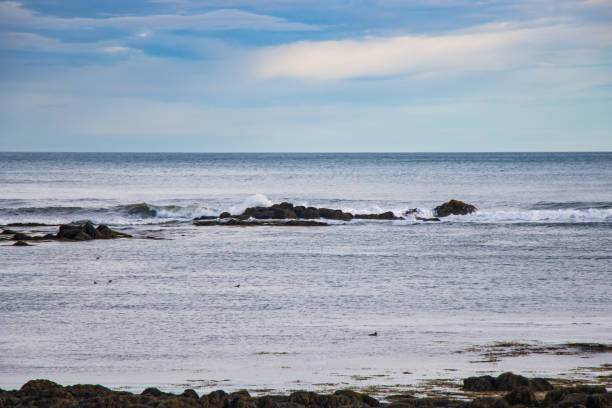氷の大西洋に沈む美しい夕日と波が岩を砕く - maine lighthouse rock sea ストックフォトと画像