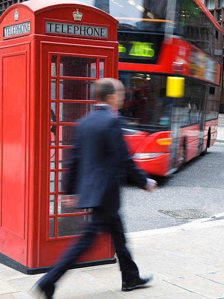 hombre de negocios caminando después de la cabina de teléfono en londres, borroso - london england business telephone booth commuter fotografías e imágenes de stock