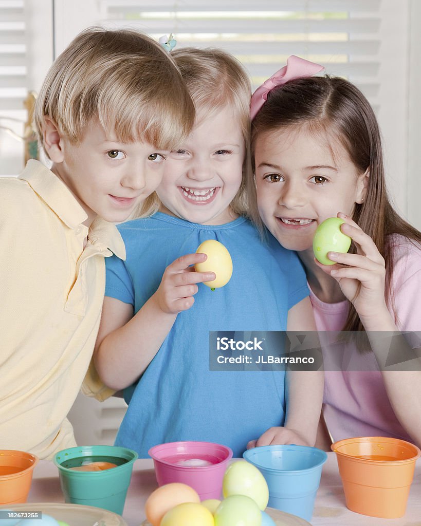 Three Happy Children with Easter Eggs Three cute children smiling as they hold up the Easter Eggs they are making.For additonal Easter images please visit my Easter Fun lightbox.Click here: 2-3 Years Stock Photo