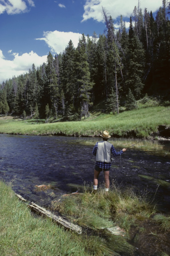 fly fisherman casts in a Montana stream
