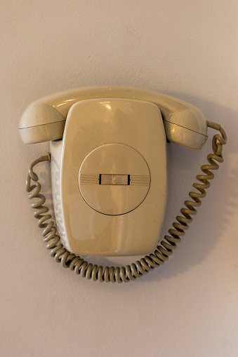 Intercom telephone with spiral cord cable used to welcome guests and open door, copy space