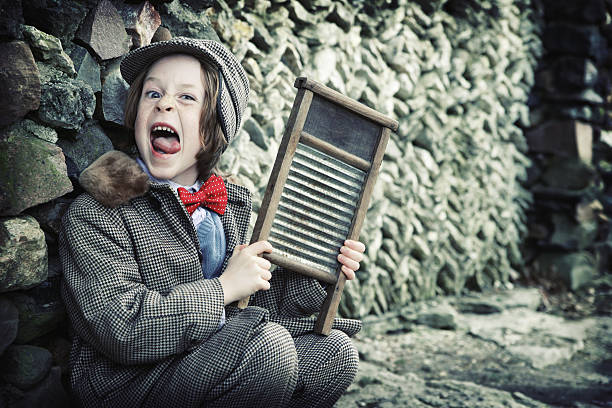 Wild Little Musician with Suit, Bow Tie and Washboard "Adorable little boy in vintage hat and jacket and red bow tie going wild with a washboard he's been playing by stone wall.Shot with Canon 1Ds Mark II, cross processed and color saturation reduced, vignette added, copy space." rockabilly boys stock pictures, royalty-free photos & images