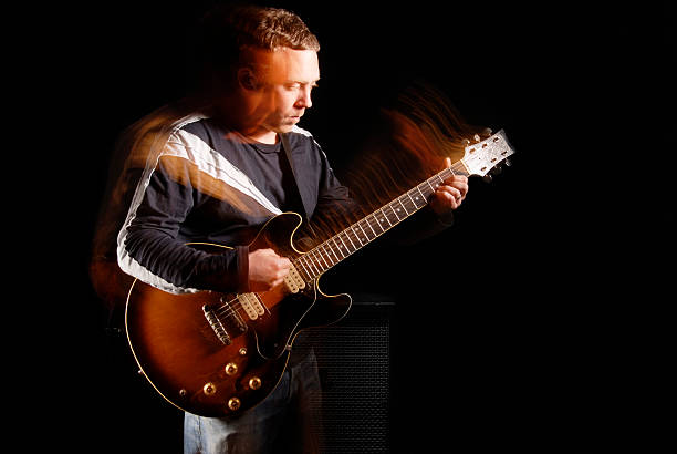 istock Male electric guitar player on black background 182674470