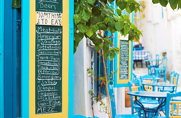 Athens, Greece. Greek tavern empty tables and chairs in a row, blur pedestrian and market background